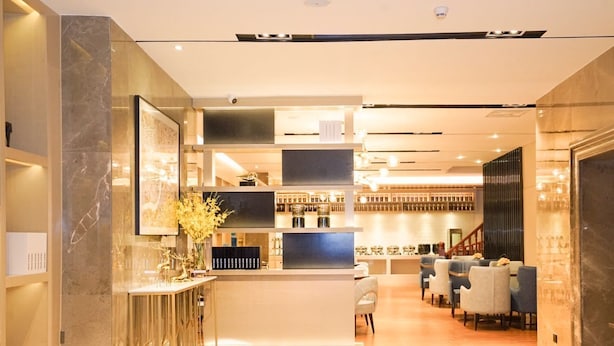 A modern hotel lobby with a marble floor, a reception desk, seating area, and a staircase. - Echarm International Hotel Canton Tower Pazhou Convention and Exhibition Center Lujiang Metro Station Branch - Free Shuttle Bus to Canton Fair Complex During Canton Fair Period  (Guangzhou)