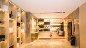 A modern hotel lobby with marble flooring, a reception desk, and a seating area. - Echarm International Hotel Canton Tower Pazhou Convention and Exhibition Center Lujiang Metro Station Branch - Free Shuttle Bus to Canton Fair Complex During Canton Fair Period  (Guangzhou)
