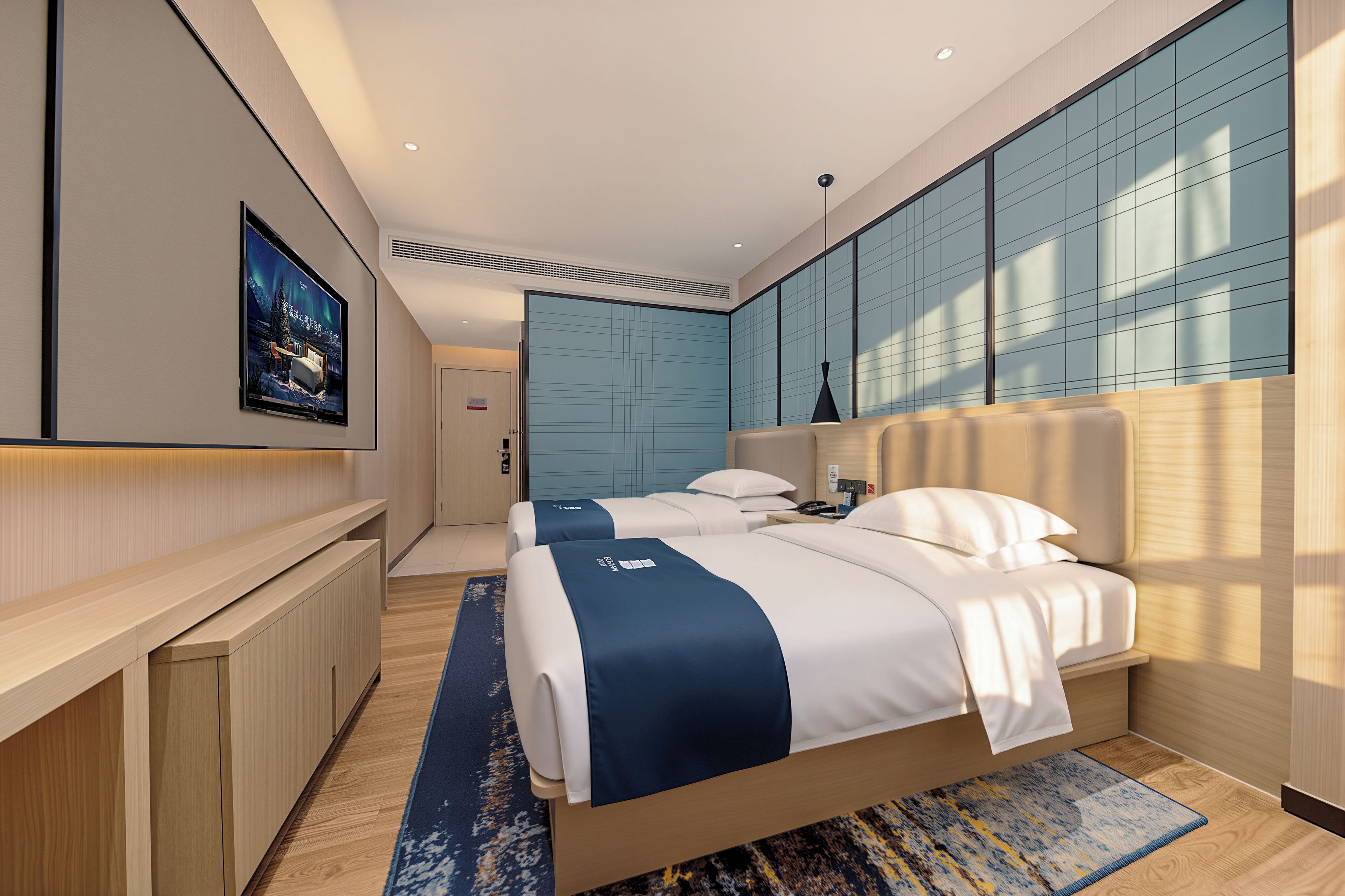 A modern hotel room with a large bed, a desk, and a wall-mounted TV.