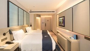 A hotel room with two beds, a desk with a lamp, a TV, and a minibar. - Echarm International Hotel Canton Tower Pazhou Convention and Exhibition Center Lujiang Metro Station Branch - Free Shuttle Bus to Canton Fair Complex During Canton Fair Period  (Guangzhou)