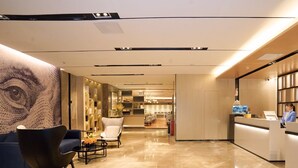 A modern hotel lobby with a reception desk, seating area, and a bar/lounge in the background. - Echarm International Hotel Canton Tower Pazhou Convention and Exhibition Center Lujiang Metro Station Branch - Free Shuttle Bus to Canton Fair Complex During Canton Fair Period  (Guangzhou)