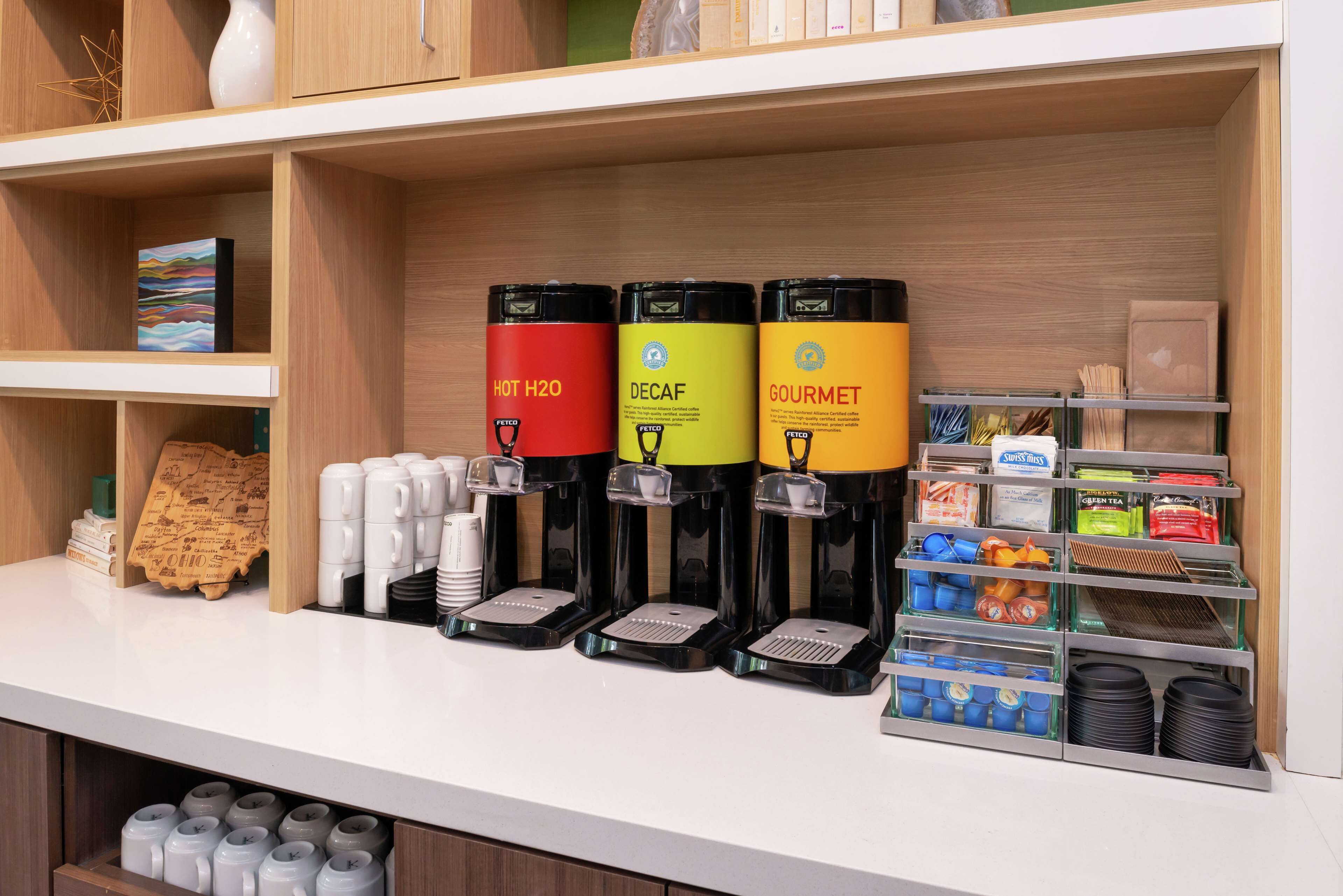 A coffee station with three dispensers labeled HOT H2O, DECAF, and GOURMET.