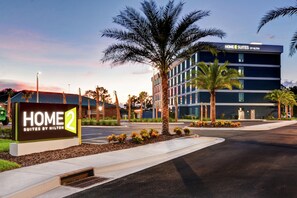A hotel entrance with a sign for 'HOME 2 SUITES BY HILTON' and a modern building with multiple floors. - Home2 Suites by Hilton Jacksonville-South/St. Johns Town Ctr (Jacksonville)