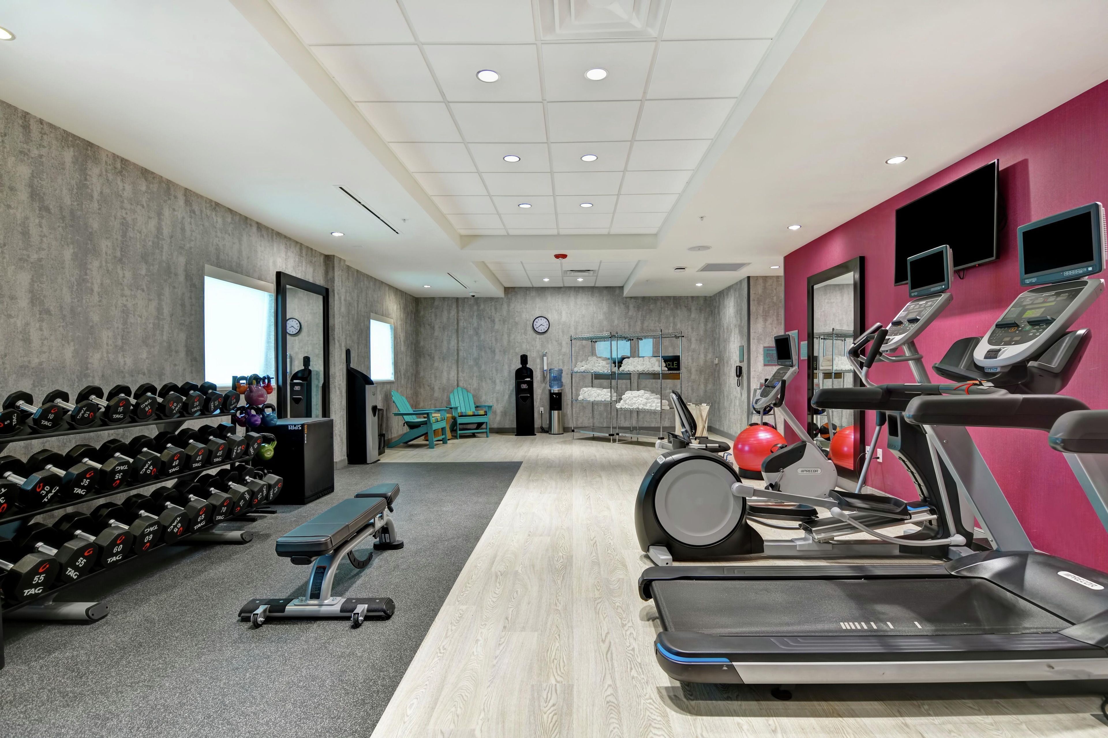 Una palestra con tapis roulant, pesi e palle da ginnastica.