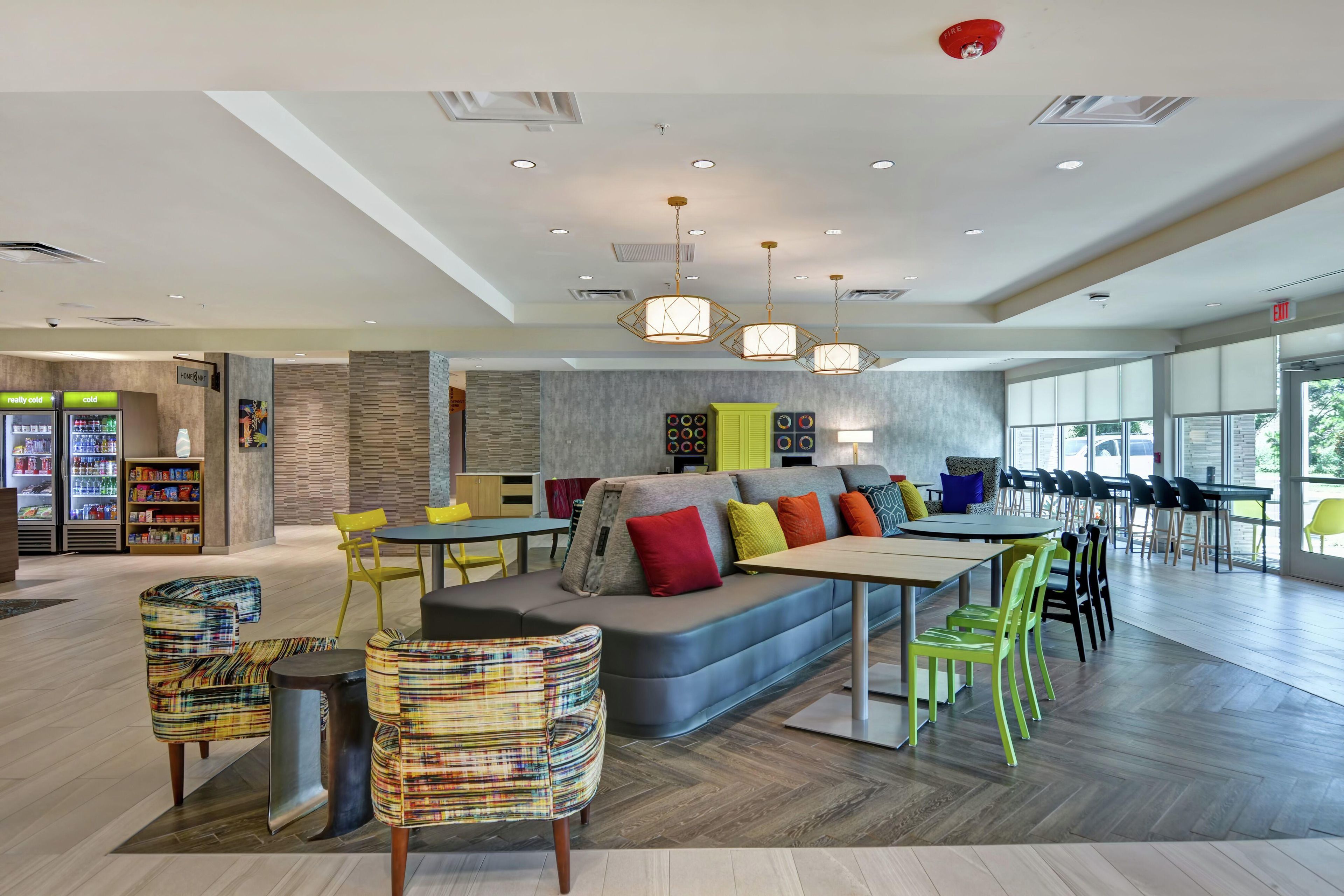 A modern interior with a seating area, tables, and a vending machine.