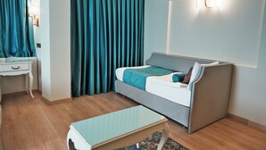 A modern hotel room with a bed, a desk, and a small table. - Taximtown Hotel (Istanbul)