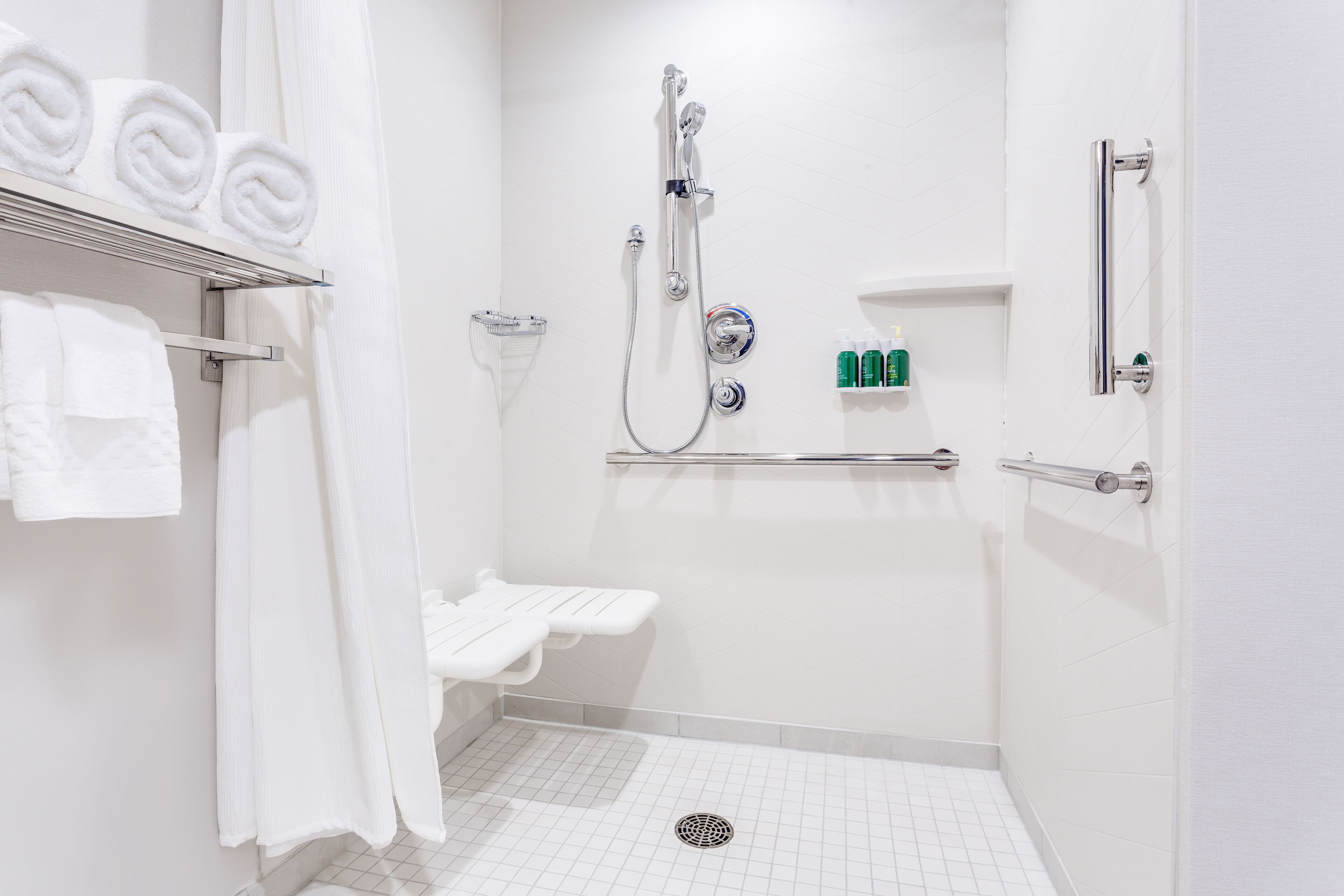 A modern bathroom with a shower, toilet, and sink.