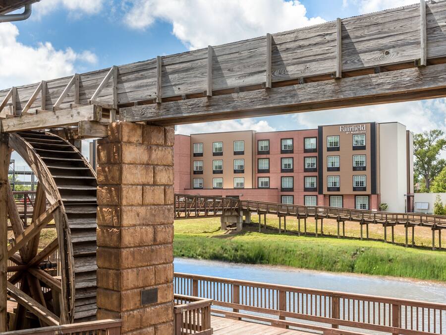 Un ponte di legno con una scala a chiocciola che conduce a un edificio con la scritta "Fairfield by Marriott".