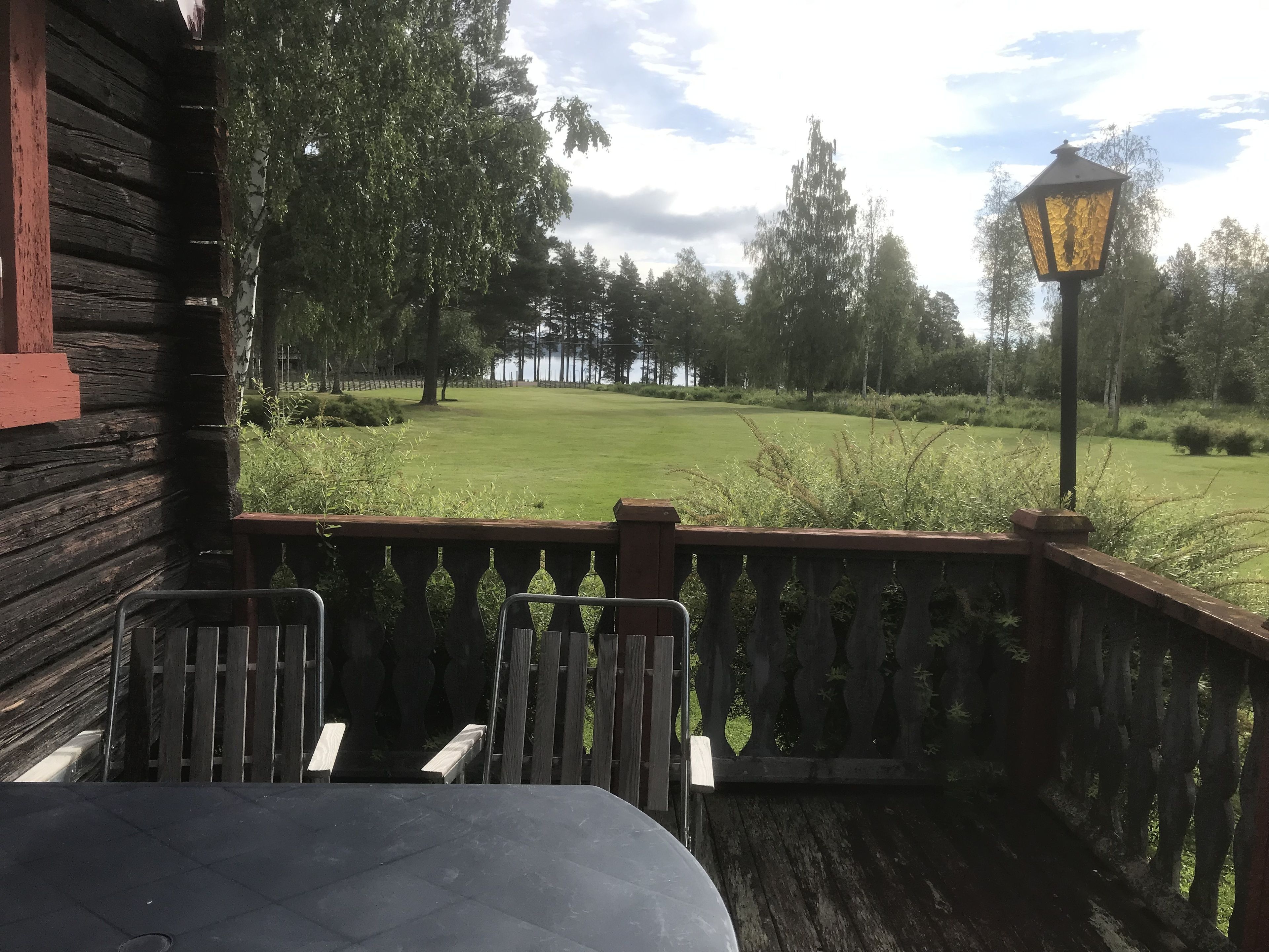 A wooden deck with a view of a golf course.