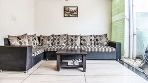 A modern living room with a sofa set, a coffee table, and a ceiling fan.