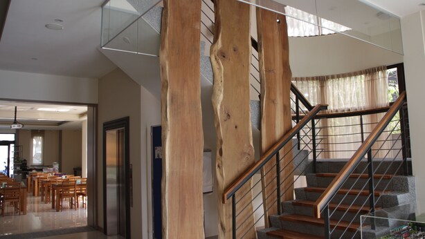 A modern interior with a wooden staircase, a dining area, and a kitchen. - Footprint Inn (Jiji)