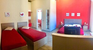 A hotel room with two beds, a red accent wall, and a bathroom visible through an open door. - EmyJo Central B&B (Naples)