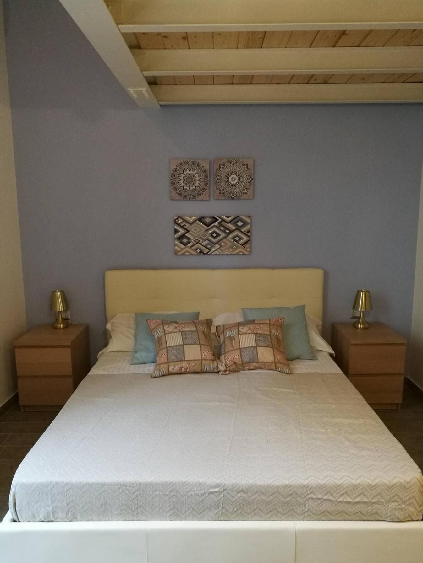 Una camera da letto con un letto, due comodini e due lampade a parete.