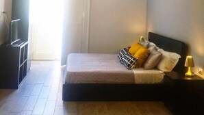 A bedroom with a bed, bedside tables, a wardrobe, and a television. - EmyJo Central B&B (Naples)