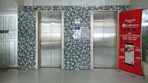 A hotel elevator with a mosaic tile wall and a RedDoorz promotional poster. - RedDoorz Plus near UV Mandaue Cebu (Mandaue)