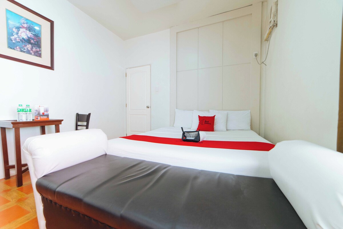 Une chambre d’hôtel avec un lit, un canapé, une petite table avec des boissons et une chaise.