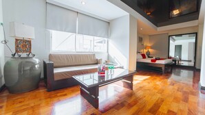 Una sala de estar moderna con una mesa de centro de vidrio, un sofá y un jarrón grande.