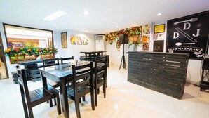 A restaurant with a wooden dining area, a black counter, and a wall decorated with various posters and a large sign. - RedDoorz Plus near San Pedro Cathedral (Davao)