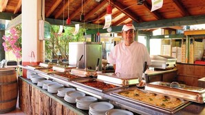A buffet setup with various food items and a chef standing behind the counter. - La Manne - Bormes les Mimosas (Bormes-Les-Mimosas)