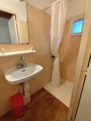 A bathroom with a sink, mirror, shower curtain, and a small window. - La Manne - Bormes les Mimosas (Bormes-Les-Mimosas)
