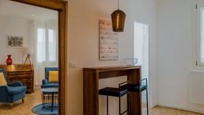 A modern living room with a wooden coffee table, blue armchairs, and a hanging pendant light. - Ca' Dandolo (Venice)
