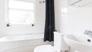 Une salle de bain moderne avec une baignoire blanche, des toilettes et un lavabo.