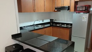 Une cuisine compacte dotée d’un îlot central, de meubles en bois et d’appareils électroménagers modernes.