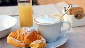 A croissant, a cup of coffee, and a glass of orange juice on a table. - Sapore di mare 5 Terre Affittacamere (La Spezia)