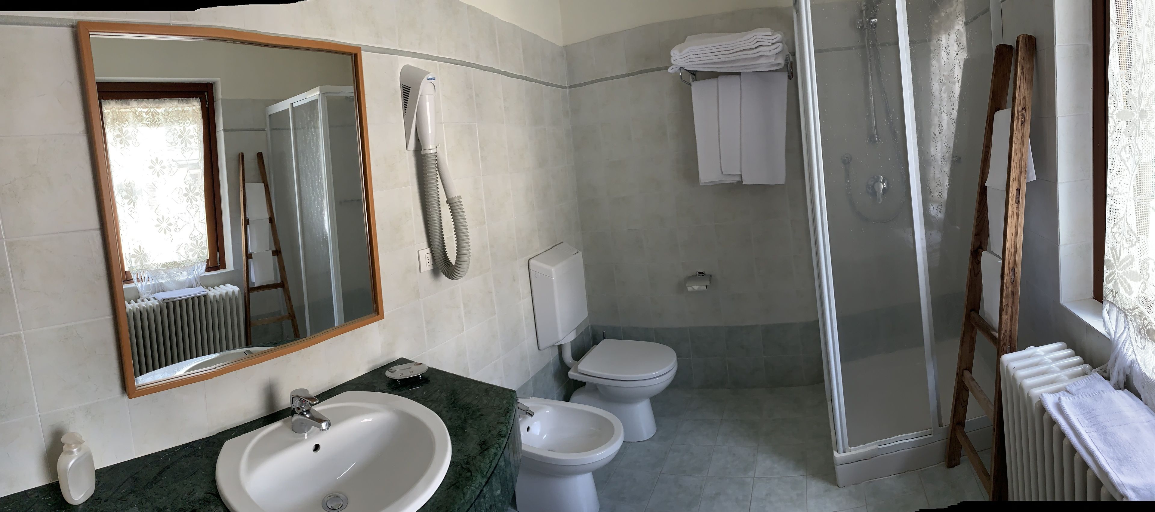 Une salle de bain équipée d’un lavabo, d’un bidet, de toilettes et d’une douche à parois de verre.