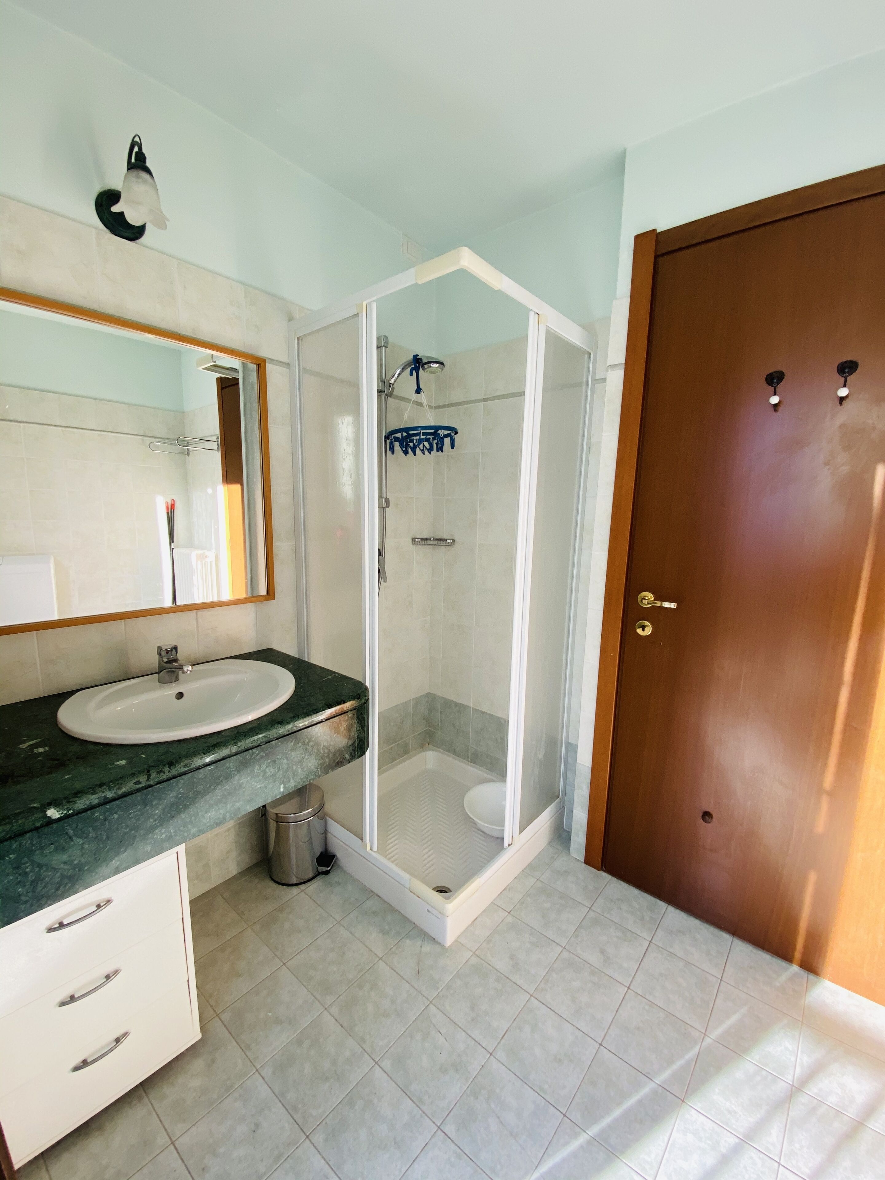 A bathroom with a sink, mirror, shower, and toilet.