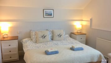 A neatly arranged bedroom with a bed, two bedside tables, and a wall-mounted picture.