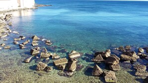 Una zona costera con agua cristalina y rocas dispersas.