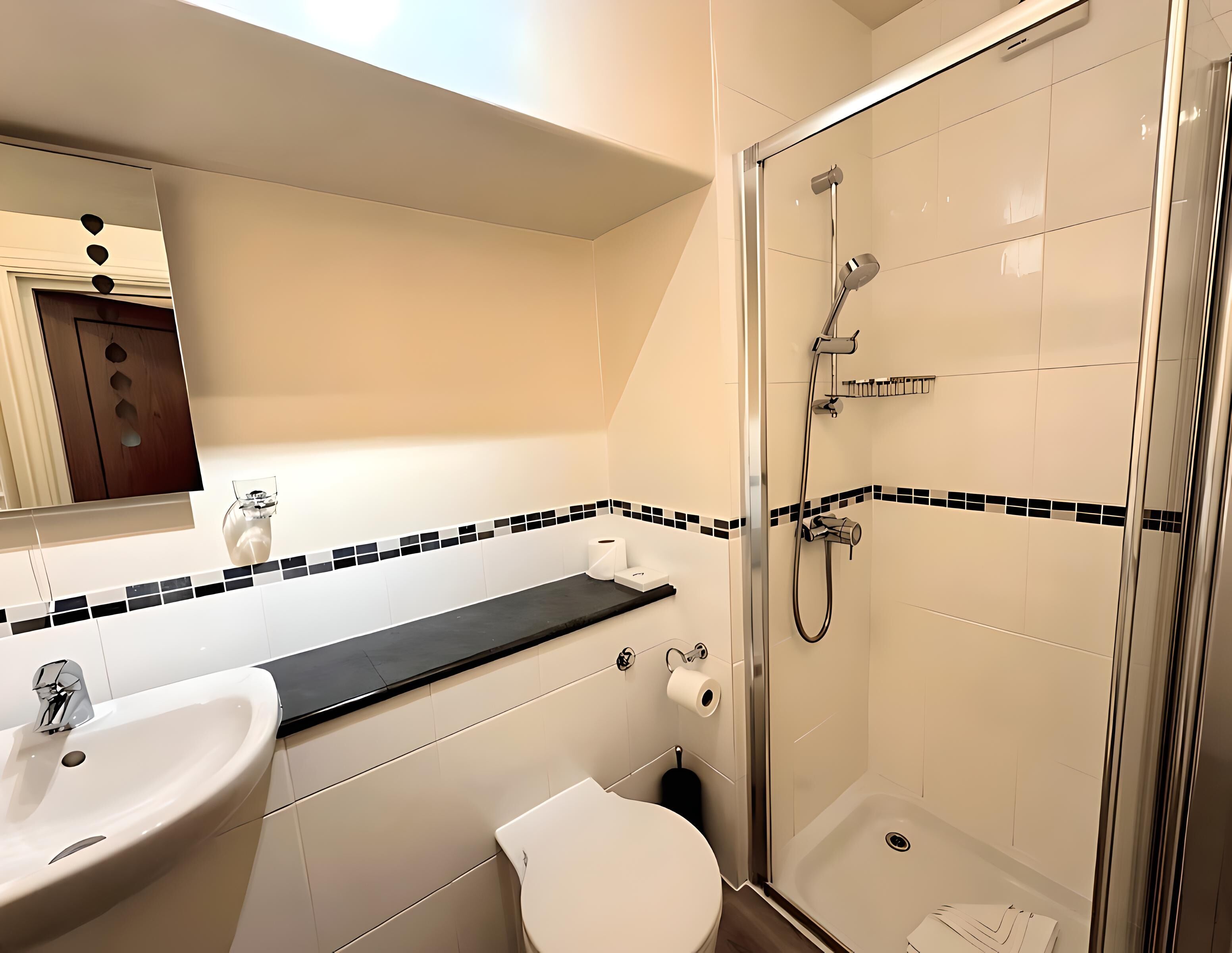 A modern bathroom with a sink, toilet, and glass-enclosed shower.