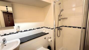 A modern bathroom with a sink, toilet, and glass-enclosed shower.