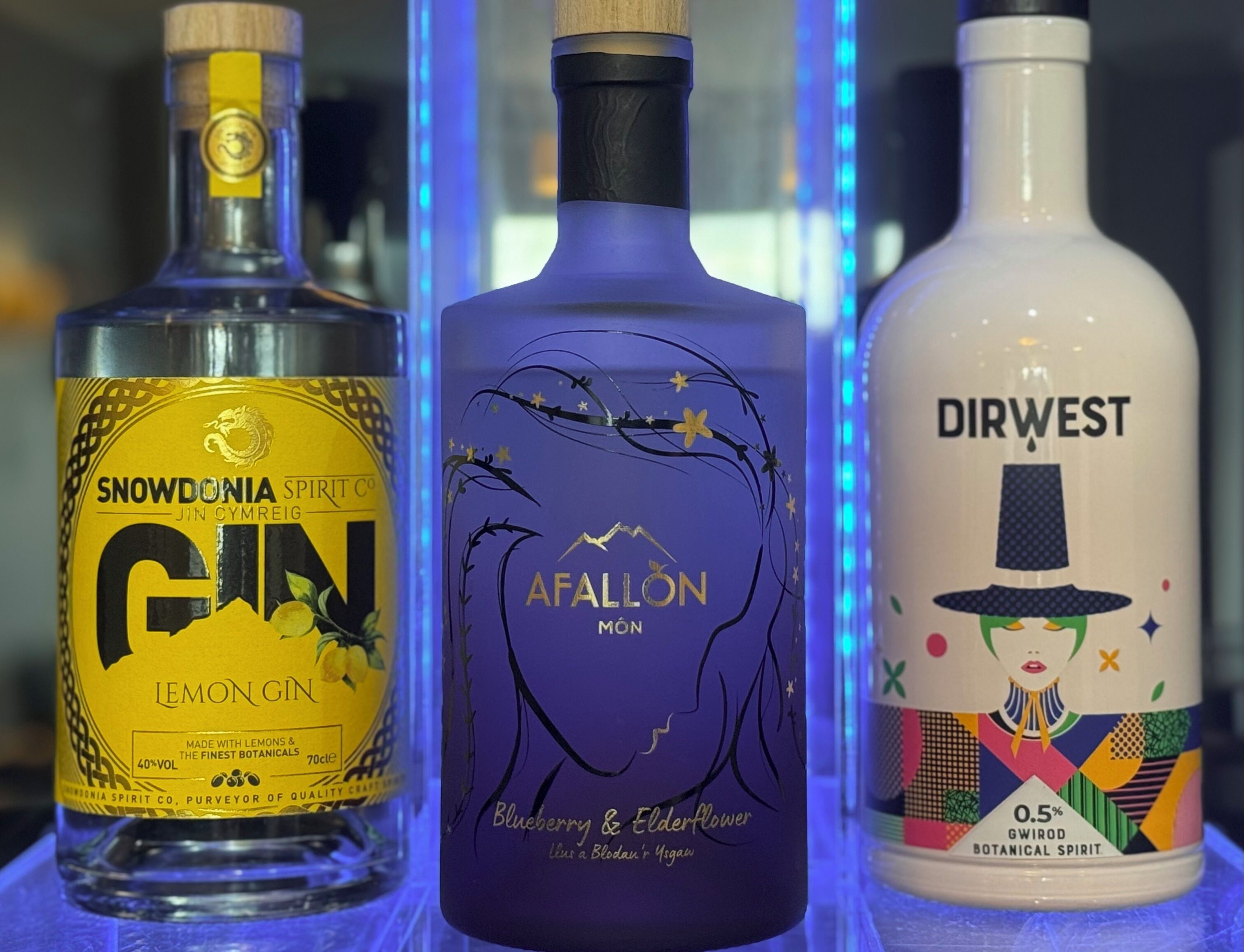 Tres botellas de ginebra con etiquetas diferentes.