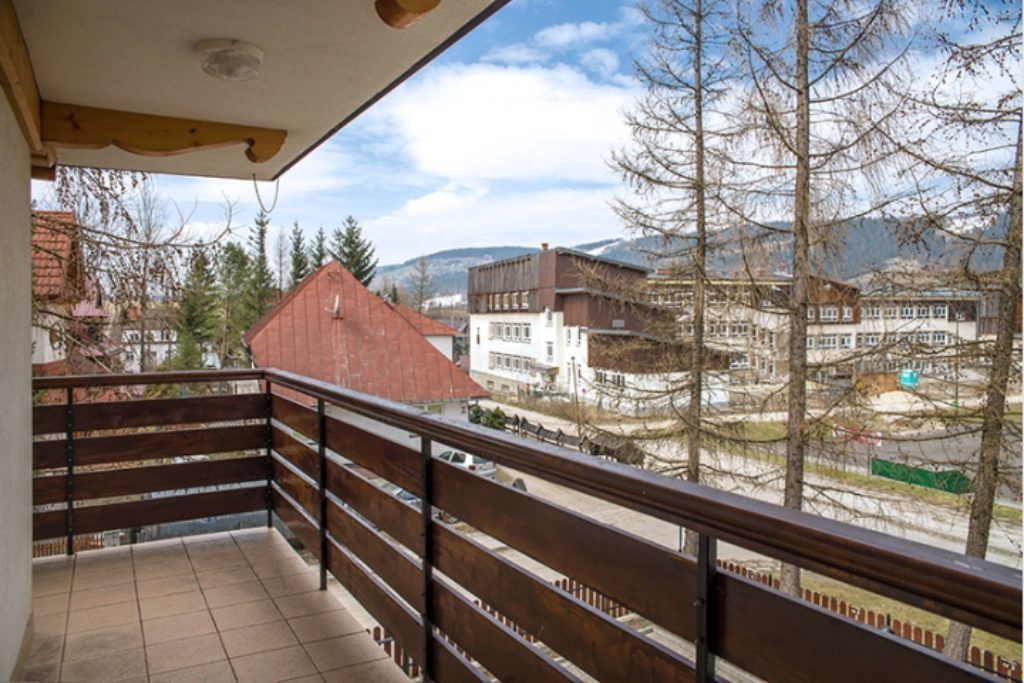 A balcony with a view of buildings and trees.