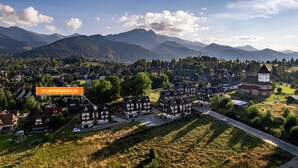 En landsby med traditionelle huse, en kirke og bjerge i baggrunden.