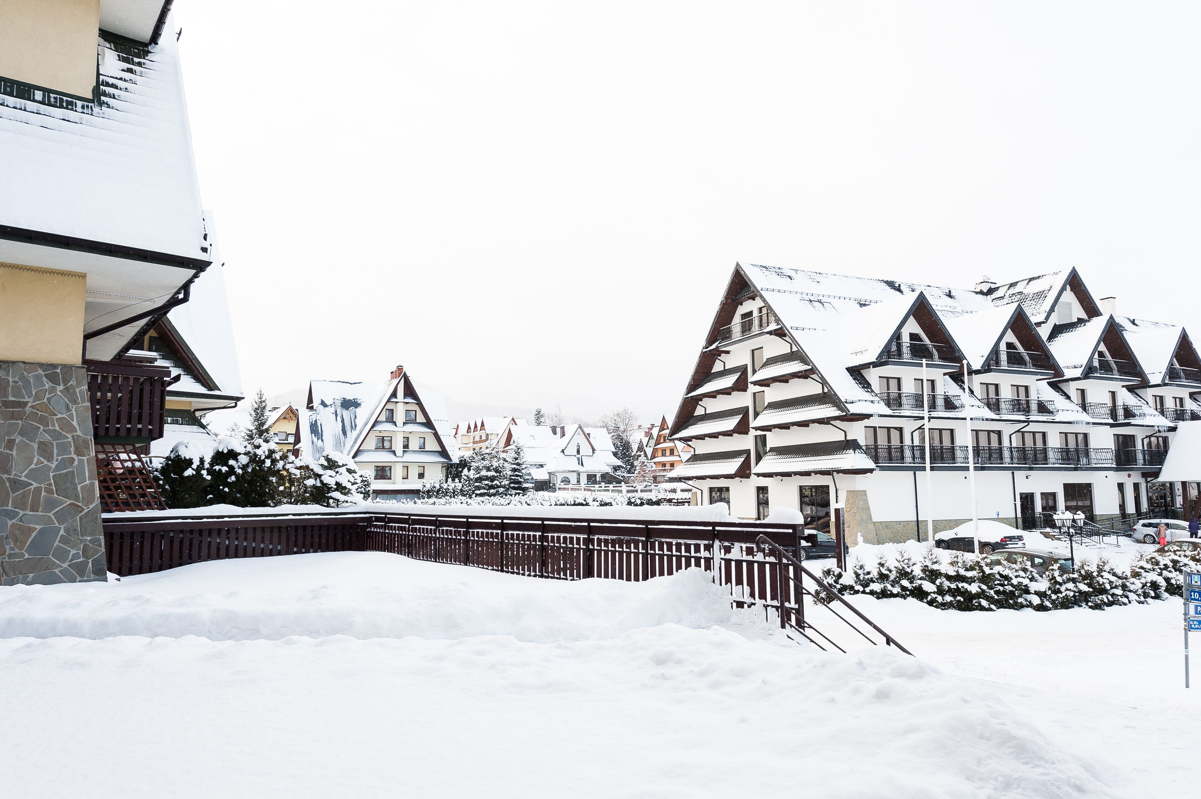 A snow-covered building with a stone facade and multiple balconies.