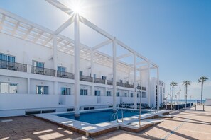 A modern hotel with a rooftop pool, white exterior, and balconies with railings. - Don Ignacio (Nijar)