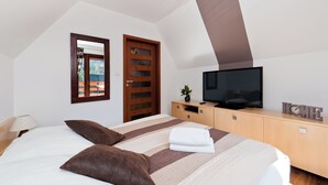 Une chambre à coucher avec un lit, une télévision, une armoire en bois et une fenêtre.