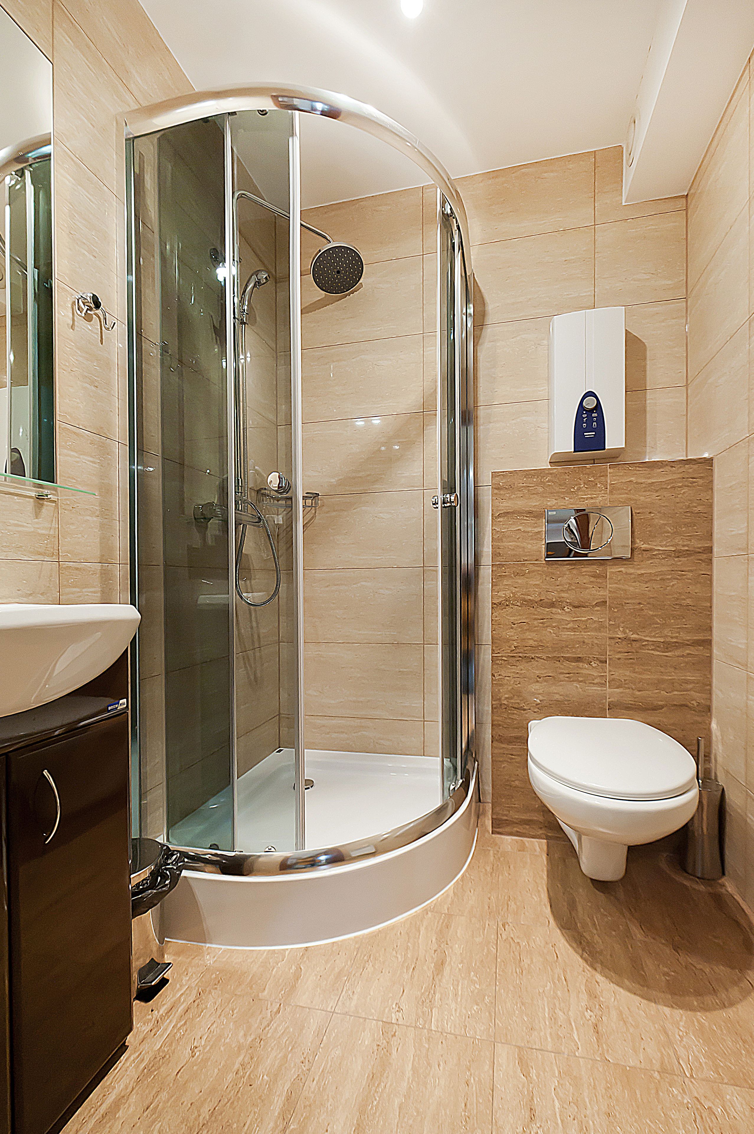 A modern bathroom with a glass-enclosed shower, a white toilet, and a sink.