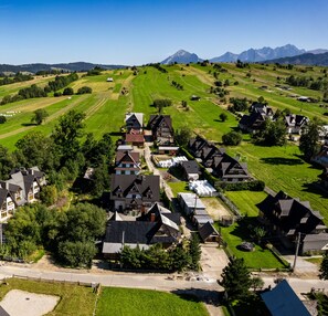 Vista aérea de una zona residencial con casas, una carretera y una cadena montañosa al fondo.