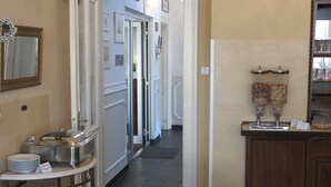 A hotel corridor with a buffet area on the left, featuring a buffet counter, plates, and a coffee machine. - Hotel Kronprinzen (Bonn)
