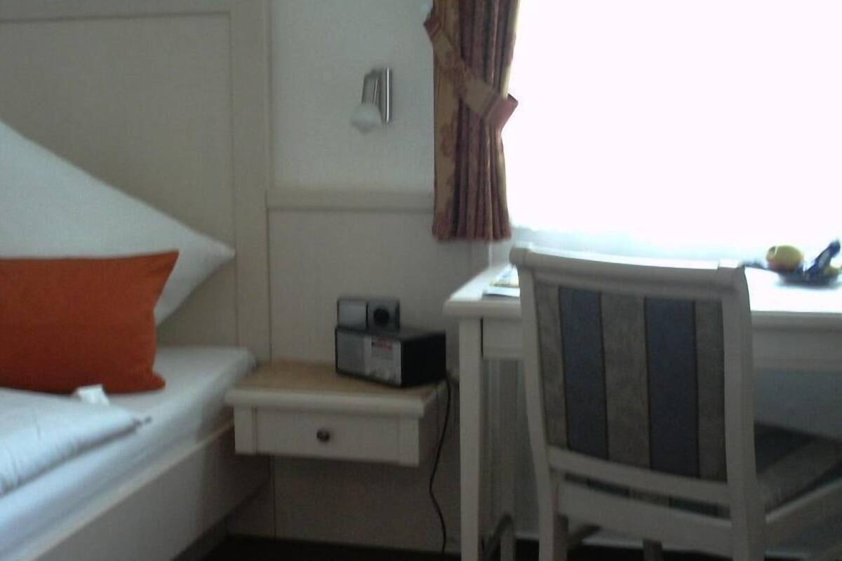Habitación de hotel con cama, escritorio y silla.