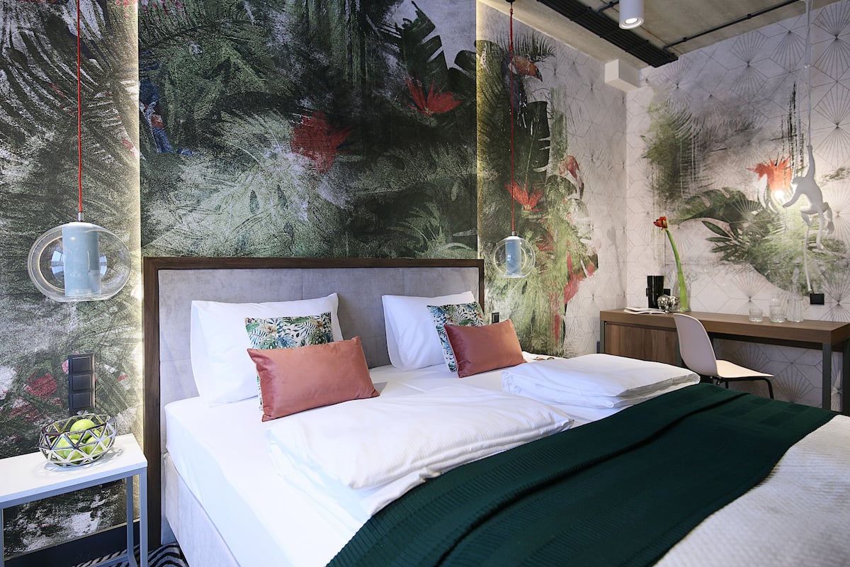 Quarto moderno com uma cama grande, uma escrivaninha e uma cadeira.