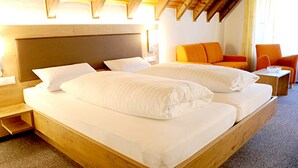 A double bed with white linens in a hotel room with wooden headboard and side tables. - Hotel Restaurant Pension Krone Post (Simonswald)