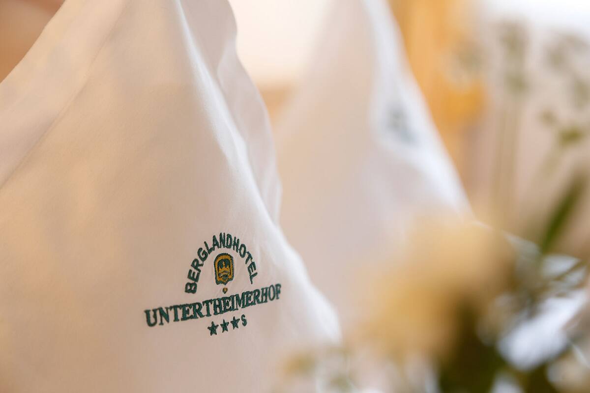 A white garment with a logo and text indicating affiliation with Berglandhotel and Unterheimerhof.