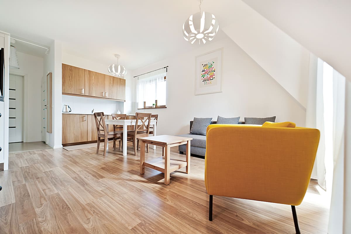 Un espacio habitable moderno con comedor, sofá y cocina.