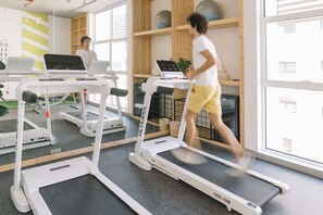 A gym with treadmills, a mirrored wall, and wooden shelves with exercise balls. - Dara Al Yamamah Hotel (Jeddah)
