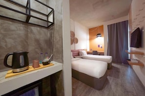 A hotel room with a kitchenette, two beds, a TV, and a bathroom visible through an open door. -  Dara Al Yamamah Hotel (Jeddah)